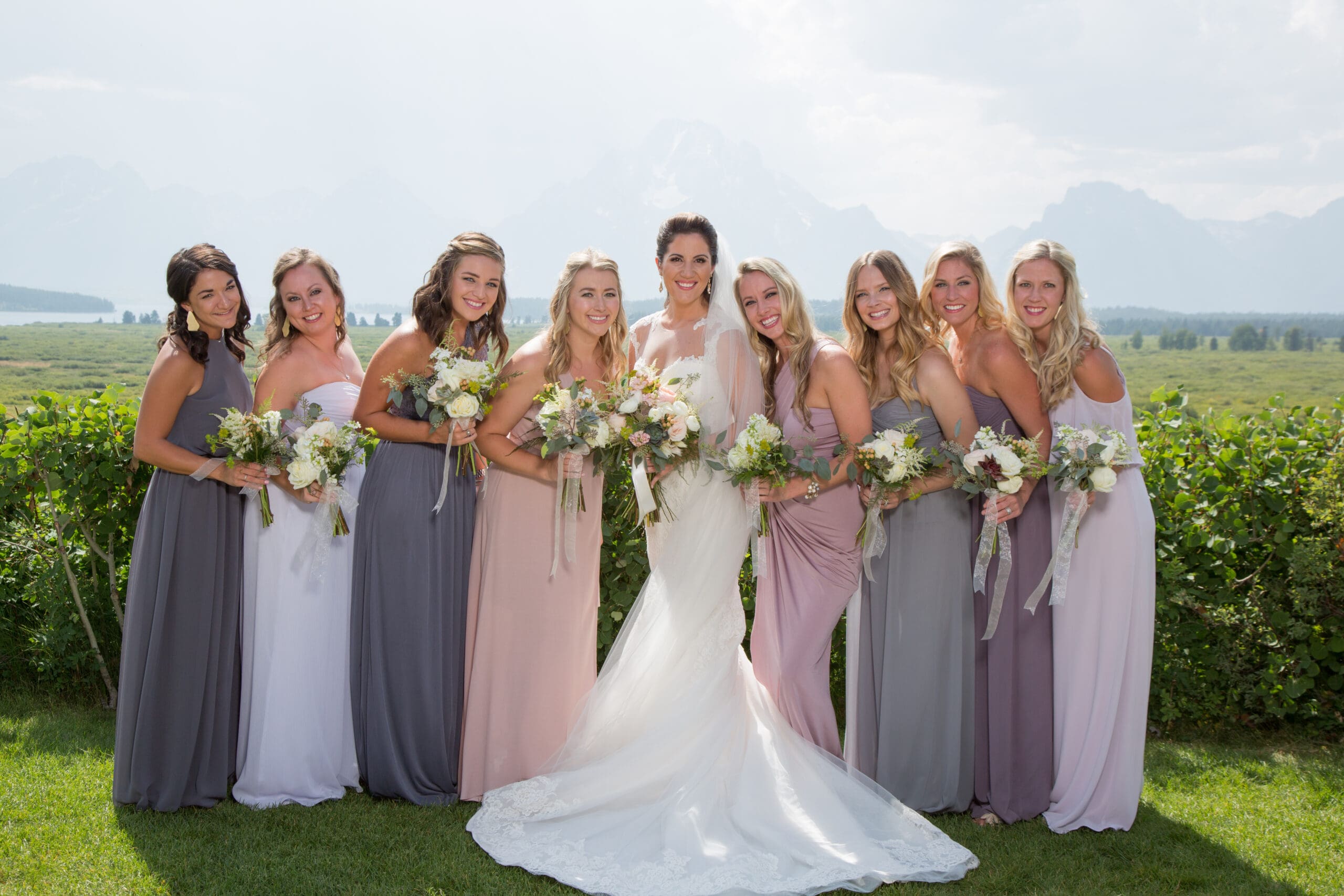 Bridesmaids in front of the mountains in the summer with mutlicolored dresses
