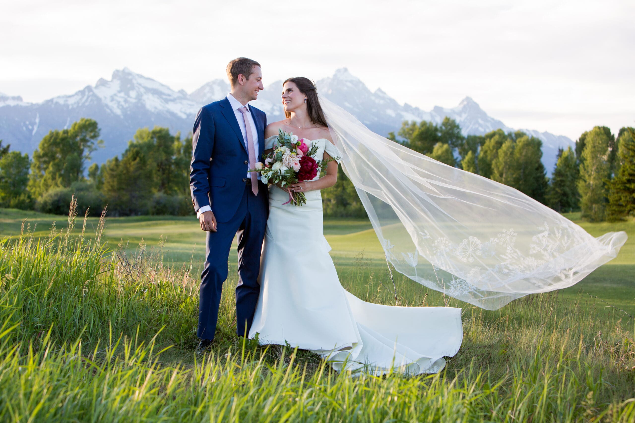 A bride and groom in front of the Grand Teton mountains