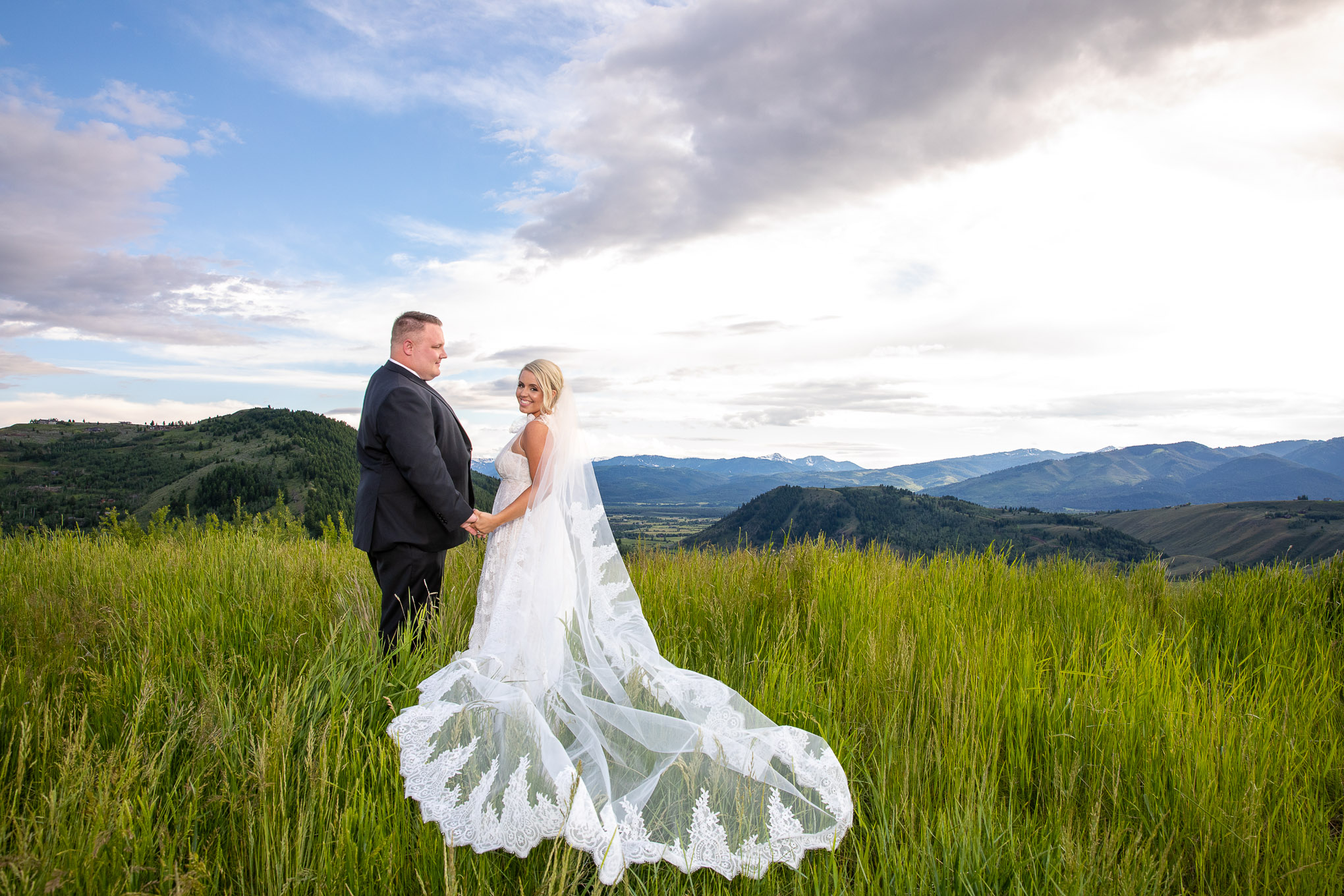 A married wedding couple stand under a sunset in Jackson Hole, Wyoming